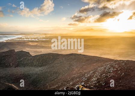 Luftaufnahme des Vulkans und des Dorfes auf lanzarote während des Sonnenaufgangs Stockfoto