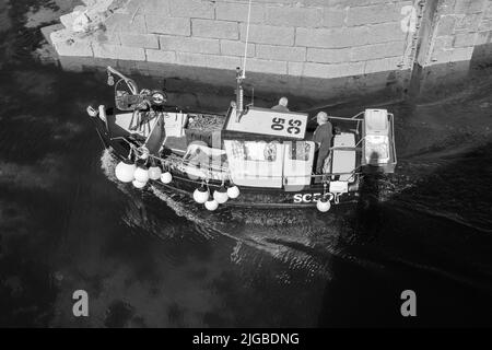 Boote, die Porthleven Harbour, Cornwall verlassen Stockfoto