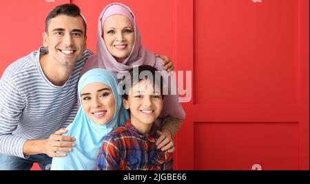 Porträt einer glücklichen muslimischen Familie auf rotem Hintergrund mit Platz für Text Stockfoto