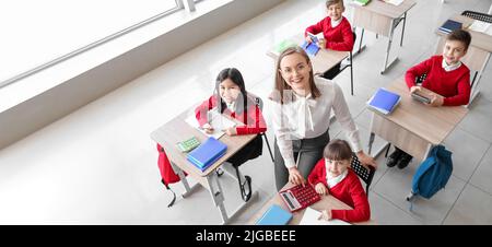 Kinder und Mathematiklehrer während des Unterrichts im Klassenzimmer, Draufsicht Stockfoto