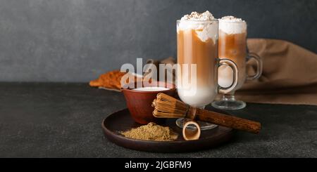 Glastasse aus vereistem Hojicha Latte, Chasen und Pulver auf schwarzem Hintergrund mit Platz für Text Stockfoto