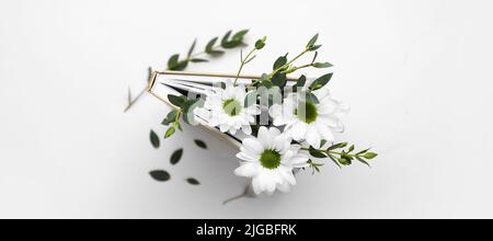 Buch mit frischen Blumen auf weißem Hintergrund, Draufsicht Stockfoto