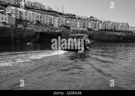 Boote, die Porthleven Harbour, Cornwall verlassen Stockfoto