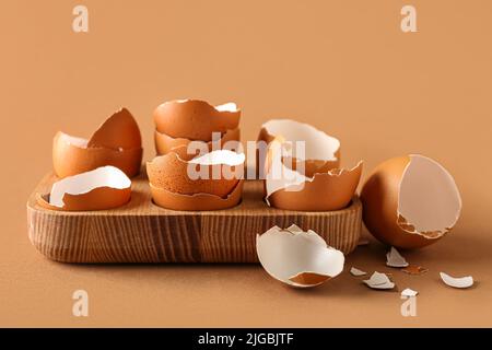 Holzhalter mit Eierschalen auf farbigem Hintergrund Stockfoto