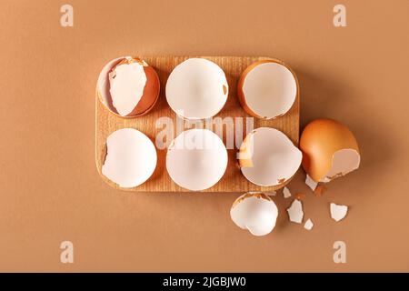 Holzhalter mit Eierschalen auf farbigem Hintergrund Stockfoto