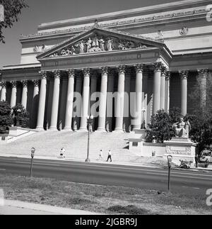 1960s, historischer Blick aus dieser Zeit auf das Äußere des großen Säulengebäudes, des Nationalarchivs der Vereinigten Staaten von Amerika, Washington, DC, USA. Das Museum wurde im neoklassischen Stil von John Russell Pope mit seinen markanten 53 Meter hohen Säulen entworfen und beherbergt die Verfassung, die Bill of Rights und die Unabhängigkeitserklärung. Eiswagen auf dem Bürgersteig. Stockfoto