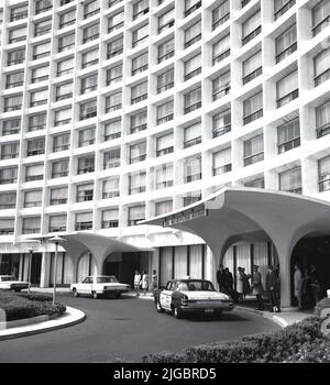 1960s, historisches Gebäude, Außenansicht des Washington Hilton, Washington, DC, USA, mit einem Taxi der Yellow Cab Company am Hoteleingang. Das Four Oaks Restaurant auf der linken Seite. Das große Hotel an der Connecticut Avenue mit über 1.000 Zimmern wurde von William B. Tabler entworfen und 1965 eröffnet. Stockfoto