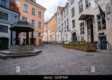 Touristen sitzen am Cat's Well in der Rataskaevu Street inmitten von Gebäuden in der Altstadt Stockfoto