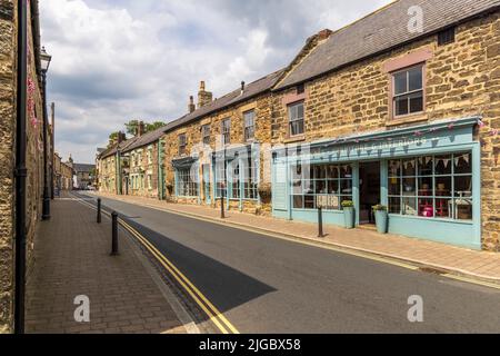 Geschäfte und Häuser entlang der Middle Street in Corbridge, Northumberland, England Stockfoto