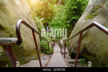 Steile schmale Treppe mit Eisengeländer zwischen den Sandsteinblöcken im Steingarten Adersbach, Tschechien Stockfoto