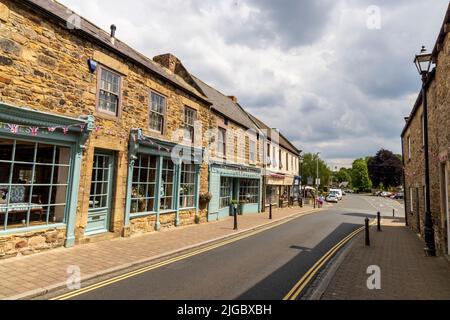 Geschäfte und Häuser entlang der Middle Street in Corbridge, Northumberland, England Stockfoto