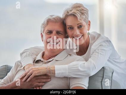 Hes my Forever. Beschnittenes Porträt eines liebevollen Seniorenpaares, das sich zu Hause in seinem Wohnzimmer entspannt. Stockfoto