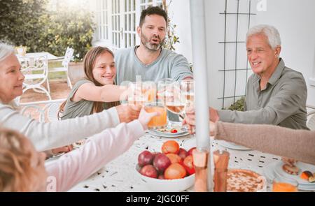 Eine Familie muss sich nicht perfektionieren, eine Familie zu Hause mit Weingläsern toasten. Stockfoto