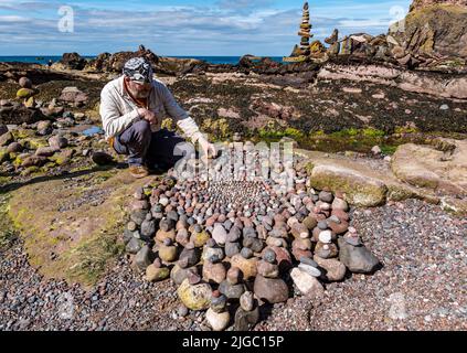 Dunbar, East Lothian, Schottland, Großbritannien, 9.. Juli 2022. European Stone Stacking Championship: Die Teilnehmer haben 3,5 Stunden Zeit, ein künstlerisches Kunstwerk aus den Felsen am Eye Cave Beach zu kreieren. Im Bild: James Brunt, Landkünstler Stockfoto