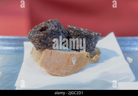 Leckeres spanisch (Pincho oder Tapa) bestehend aus Brot und Reiswurst. Selektiver Ansatz. Stockfoto