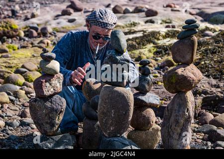 Dunbar, East Lothian, Schottland, Großbritannien, 9.. Juli 2022. European Stone Stacking Championship: Teilnehmer aus der ganzen Welt haben 3,5 Stunden Zeit, um ein künstlerisches Kunstwerk aus den Felsen am Eye Cave Beach zu kreieren. Im Bild: Charlie Jordan aus Texas. Kredit: Sally Anderson/Alamy Live Nachrichten Stockfoto