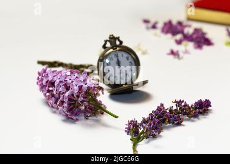 Unschärfe-Effekte für alte Uhren. Konzept des Vergehens, die Uhr zerfällt in Stücke. Analoge Uhr mit Dispergiereffekt. Konzept Leben und Tod. Fliederfluss Stockfoto