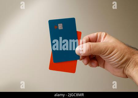 Grüne und orangefarbene kontaktlose Kredit- oder Debitkarten mit kontaktlosem Zeichen. Digitales Zahlungssystem. Stockfoto