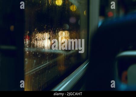 Das Innere eines Busses mit Blick auf ein Fenster und Regentropfen Stockfoto