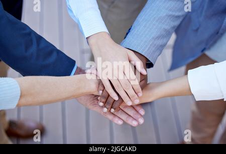 Alle Hände an Deck. In einem hohen Winkel eine Gruppe von nicht erkennbaren Geschäftsleuten, die draußen mit den Händen in einem Geheule stehen. Stockfoto