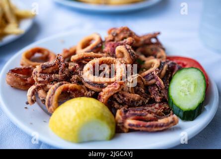 Gebratene Tintenfisch-Schale mit Zitrone. Traditionelle mediterrane Küche auf griechischen Inseln, Griechenland Stockfoto