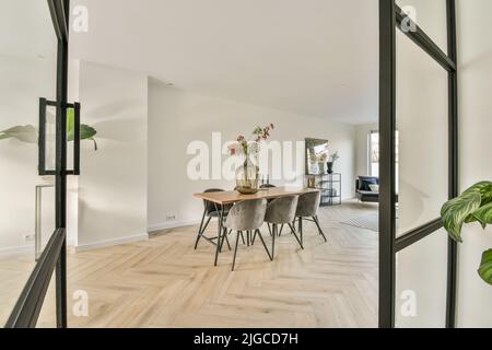 Geräumiges Esszimmer mit Tisch und Stühlen in moderner Wohnung In minimalistischem Stil Stockfoto