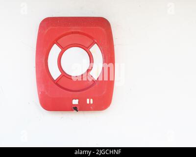 Leuchtend rote moderne Rettungsboje an der Wand. Stockfoto
