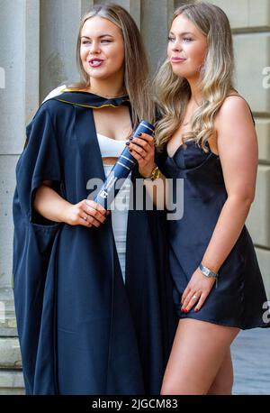 Glamouröse Studentinnen der Dundee University posieren, um ihre Fotos auf dem Dundee City Square, Schottland, machen zu lassen Stockfoto