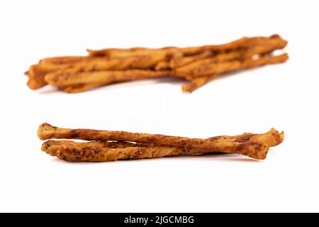 Gesalzene gebackene Sticks mit Sesam und Mohnsamen isoliert auf hellem Hintergrund. Selektiver Fokus. Stockfoto