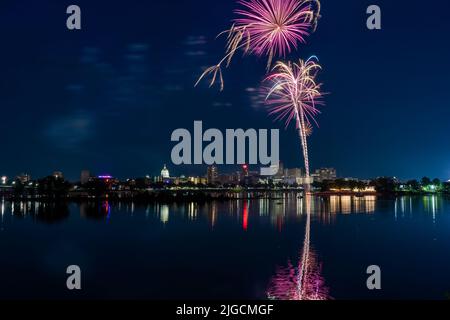 Harrisburg, Pennsylvania - 4. Juli 2022: Ein Blick auf das Feuerwerk vom 4.. Juli über der Stadt Harrisburg, das im Susquehanna River reflektiert wird. Stockfoto