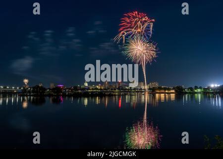 Harrisburg, Pennsylvania - 4. Juli 2022: Ein Blick auf das Feuerwerk vom 4.. Juli über der Stadt Harrisburg, das im Susquehanna River reflektiert wird. Stockfoto