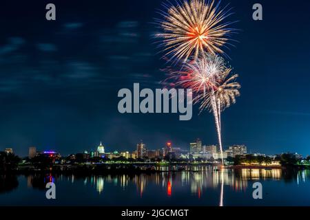 Harrisburg, Pennsylvania - 4. Juli 2022: Ein Blick auf das Feuerwerk vom 4.. Juli über der Stadt Harrisburg, das im Susquehanna River reflektiert wird. Stockfoto