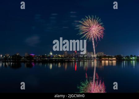 Harrisburg, Pennsylvania - 4. Juli 2022: Ein Blick auf das Feuerwerk vom 4.. Juli über der Stadt Harrisburg, das im Susquehanna River reflektiert wird. Stockfoto