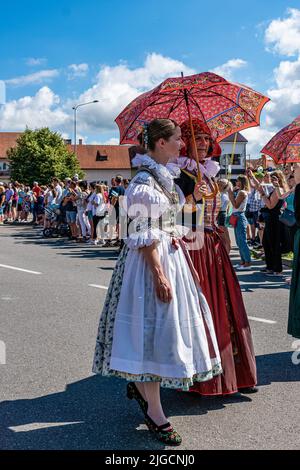 Straznice, Tschechische Republik - 25. Juni 2022 Internationales Folklore-Festival. Frauen in Trachten mit Sonnenschirm mit Volksmotiven Stockfoto