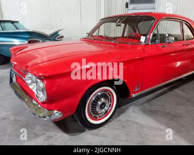 Altes rotes Chevrolet Chevy Corvair Monza Coupé 1963 in einem Lager. Seitenansicht. Expo Fierro 2022 Oldtimer-Show. Copyspace. Stockfoto