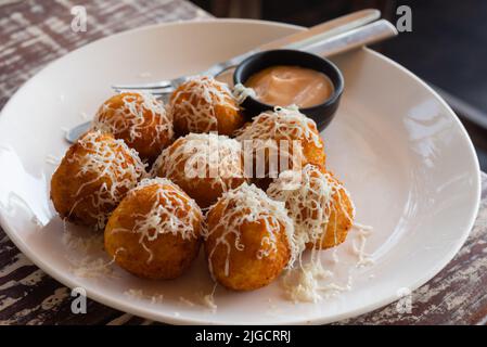 Italienische arancini. Hausgemachte Reisbällchen mit Mozzarella-Käse, Petersilie, Zitrone und Parmesan-Käse. Frittierte Käsebällchen mit Sauce Stockfoto