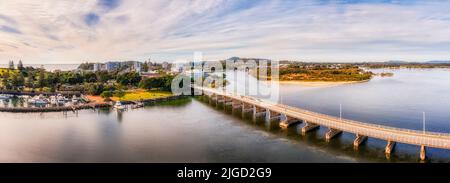 Lange Brücke zwischen Forster und Tuncrys Stadt über den Coolongolook Fluss am Wallis See in Austromaila - Luftpanorama. Stockfoto