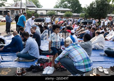 Plainfield, New Jersey, USA. 9.. Juli 2022. Ein Vater hilft seinem Sohn mit seinen Schuhen nach einer Versammlung für Eid al-Adha im Plainfield Center of Islamic Enlightenment in Plainfield, New Jersey. Eid al-Adha ist der zweite und größere der beiden wichtigsten Feiertage, die im Islam gefeiert werden. Es ehrt die Bereitschaft von Ibrahim, seinen Sohn Ismail als einen Akt des Gehorsams gegenüber Allahs Befehl zu opfern. (Bild: © Brian Branch Price/ZUMA Press Wire) Stockfoto