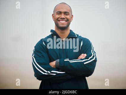 Zuversichtlich in seine sportlichen Fähigkeiten. Ein beschnittenes Porträt eines hübschen jungen Athleten, der mit nach außen gefalteten Armen steht. Stockfoto