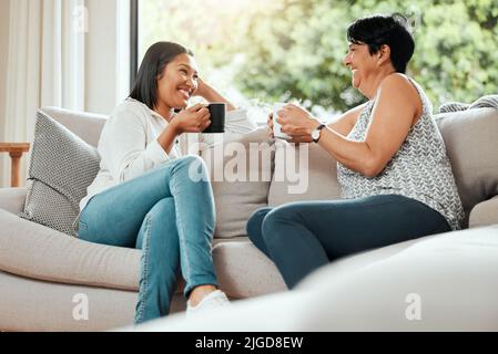 Das Universum schenkte mir die perfekte Tochter. Eine ältere Frau, die sich zu Hause auf dem Sofa mit ihrer Tochter verklebte. Stockfoto