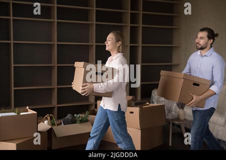 Ein zufriedenes Paar, das Pappkartons im Wohnzimmer trug Stockfoto
