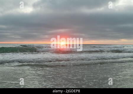 10. Juli 2022, San Diego, CA, USA: Die Korallen, Bäume, Felsen, Strand, Wellen, Orange Wolken und Meer während des glitzernden Sommeruntergangs in La Jolla, Kalifornien, am Samstag, den 9.. Juli 2022 (Bildquelle: © Rishi Deka/ZUMA Press Wire) Stockfoto