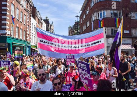 London, Großbritannien. 09.. Juli 2022. Die Demonstranten tragen während des Trans Pride marsches in Soho ein Transparent mit den Farben der Trans Pride-Flagge, auf dem steht: „Transgender-Rechte sind Menschenrechte“. Tausende von Menschen marschierten durch das Zentrum Londons, um die Rechte von Trans zu unterstützen. Kredit: SOPA Images Limited/Alamy Live Nachrichten Stockfoto