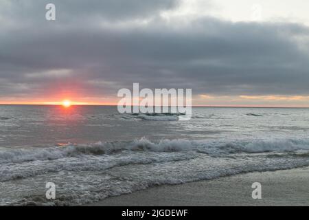 10. Juli 2022, San Diego, CA, USA: Die Korallen, Bäume, Felsen, Strand, Wellen, Orange Wolken und Meer während des glitzernden Sommeruntergangs in La Jolla, Kalifornien, am Samstag, den 9.. Juli 2022 (Bildquelle: © Rishi Deka/ZUMA Press Wire) Stockfoto