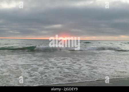 10. Juli 2022, San Diego, CA, USA: Die Korallen, Bäume, Felsen, Strand, Wellen, Orange Wolken und Meer während des glitzernden Sommeruntergangs in La Jolla, Kalifornien, am Samstag, den 9.. Juli 2022 (Bildquelle: © Rishi Deka/ZUMA Press Wire) Stockfoto