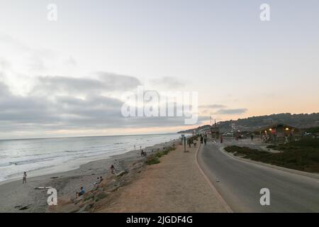 10. Juli 2022, San Diego, CA, USA: Die Korallen, Bäume, Felsen, Strand, Wellen, Orange Wolken und Meer während des glitzernden Sommeruntergangs in La Jolla, Kalifornien, am Samstag, den 9.. Juli 2022 (Bildquelle: © Rishi Deka/ZUMA Press Wire) Stockfoto