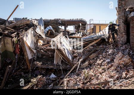 Charkiw, Ukraine. 09.. Juli 2022. An den Ruinen der zerstörten Gebäude in Charkiw ist Feuerwehrmann zu sehen. Nach Angaben der ukrainischen Beamten trifft am 9. Juli gegen 10 Uhr eine russische Kreuzfahrtrakete den zentralen Teil der Stadt Charkow, wobei mehrere Zivilisten und ein 12-jähriges Mädchen verletzt werden. (Foto von Alex Chan Tsz Yuk/SOPA Images/Sipa USA) Quelle: SIPA USA/Alamy Live News Stockfoto