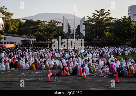 Bandung, West-Java, Indonesien. 10.. Juli 2022. Indonesische Muslime führen Eid al-Adha-Gebete vor dem Hintergrund des Tangkuban Perahu-Berges in Bandung durch. Muslime weltweit feiern Eid Al-Adha zum Gedenken an die Bereitschaft des Propheten Ibrahim, seinen Sohn als Zeichen seines Gehorsams gegenüber Gott zu opfern, während dessen sie zulässige Tiere, in der Regel Ziegen, Schafe und Kühe, opfern. (Bild: © Algi Febri Sugita/ZUMA Press Wire) Stockfoto