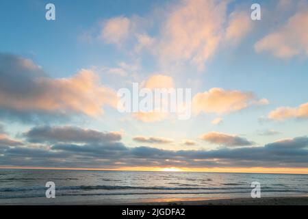 10. Juli 2022, San Diego, CA, USA: Die Korallen, Bäume, Felsen, Strand, Wellen, Orange Wolken und Meer während des glitzernden Sommeruntergangs in La Jolla, Kalifornien, am Samstag, den 9.. Juli 2022 (Bildquelle: © Rishi Deka/ZUMA Press Wire) Stockfoto