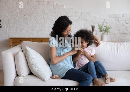 Liebende afrikanische Mama spielen mit Cutie kleine Tochter Stockfoto